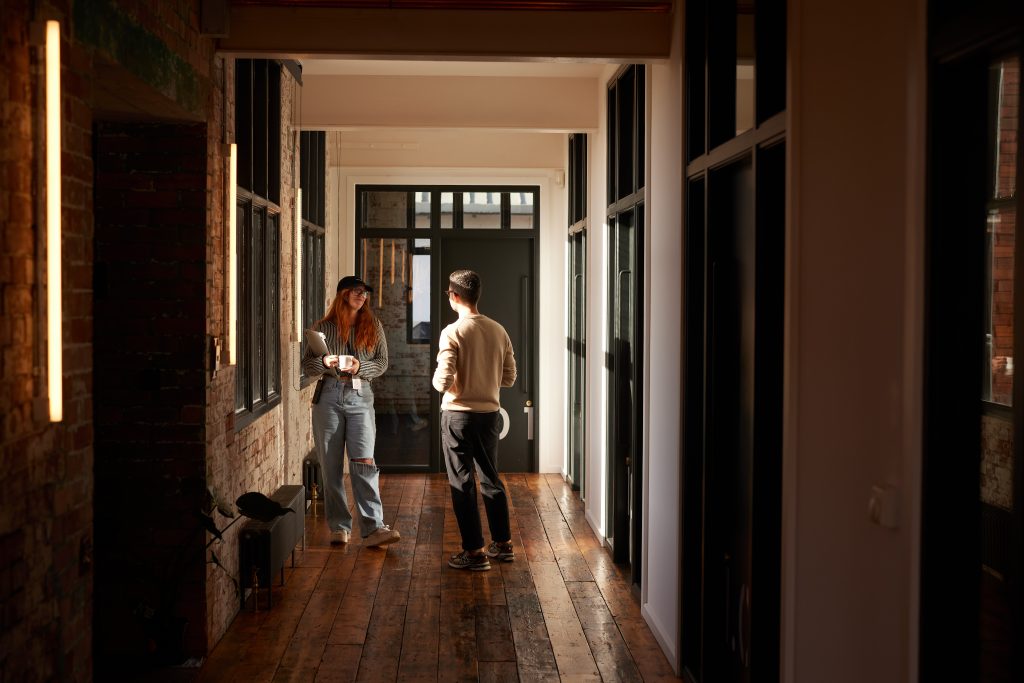 People talking in corridor smiling
