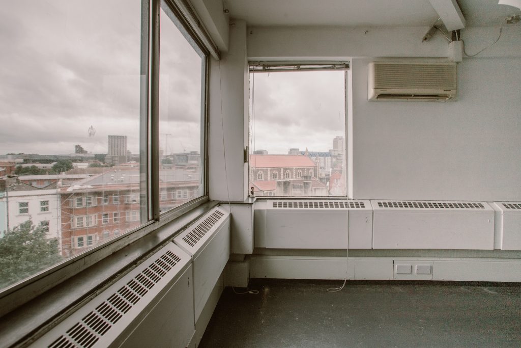 A corner office with a view out over a cityscape with a grey sky