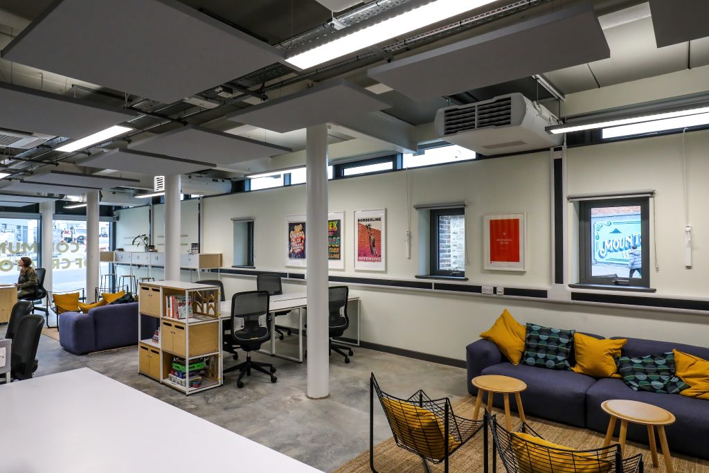 A coworking space with sofas, chairs and desks.