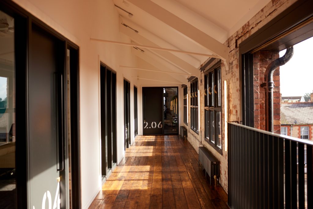 A wooden hallway with sunlight shining through the windows