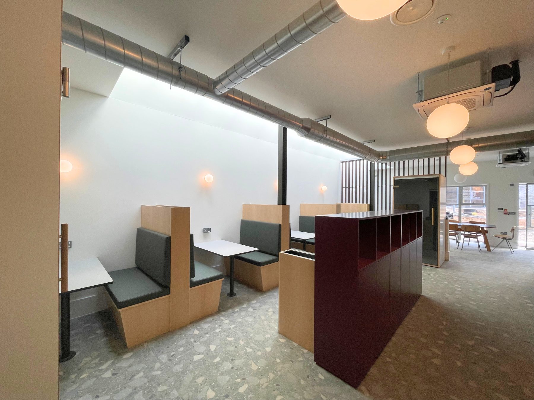 Cafe-style coworking space at Foundry in Camborne, Cornwall. A bright space with booth seating and a terrazzo floor.
